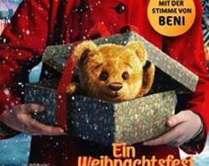 Teddy schaut aus einer Geschenkbox heraus.